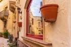 Malta, Birgu. Window reflection of narrow streets and stone buildings. Art Print